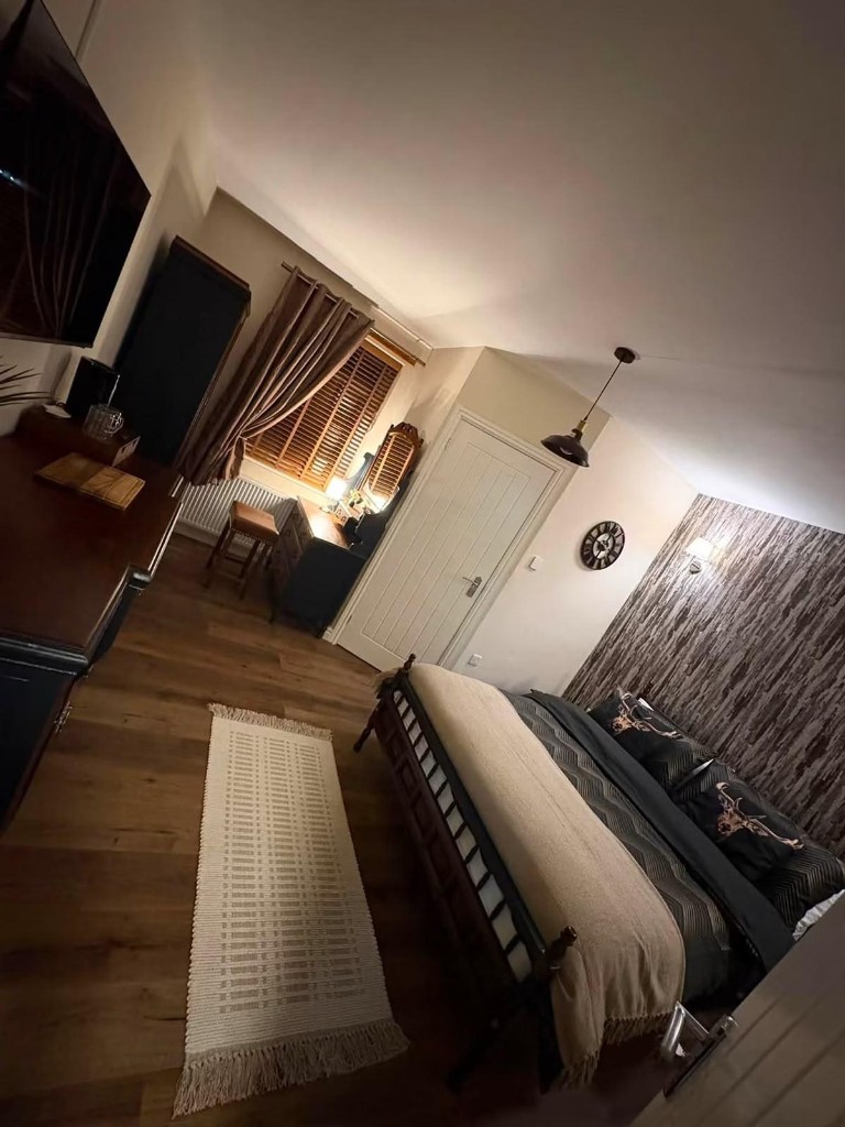 The Stag Room: a larger guest bedroom with stag-print cushions, wood flooring and warm lighting
